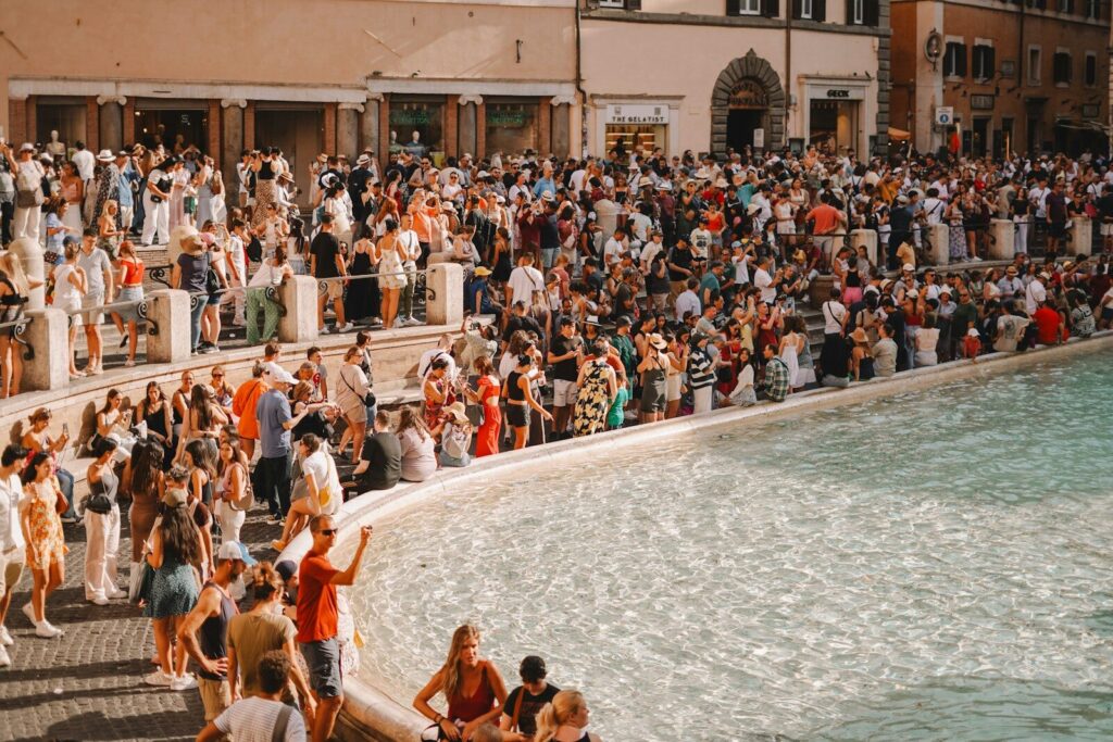 A crowd of people standing around a body of water